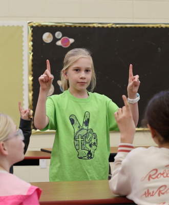 Fourth grader Ella Sutherland teaches sign language to the after school ASL Club at Stolley Park.